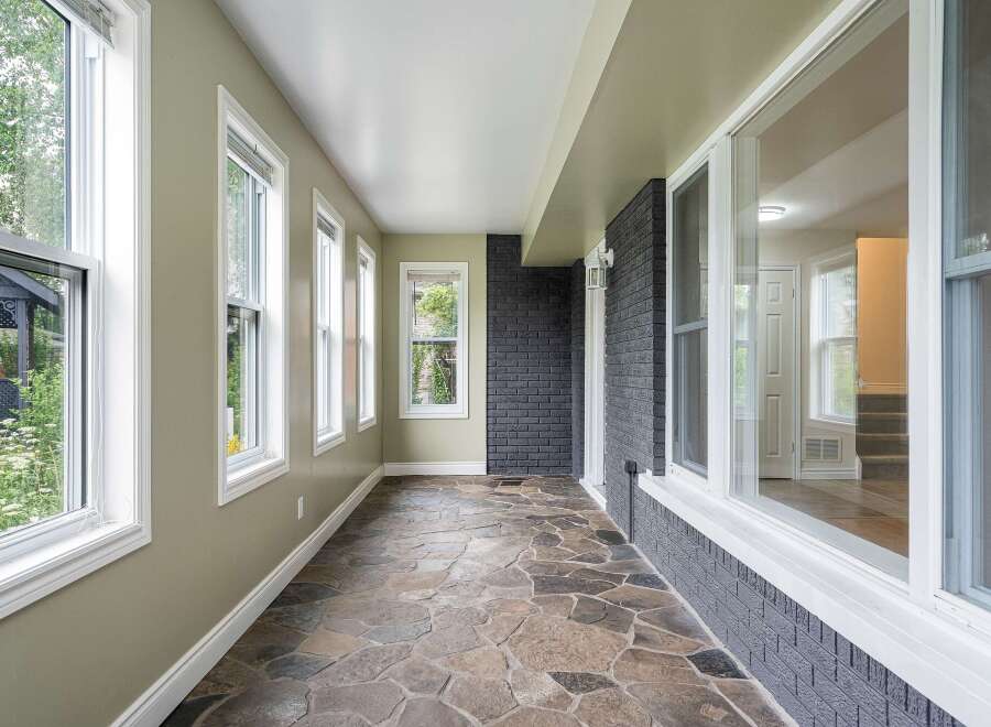 Step into this charming sunroom, featuring a unique flagstone floor that adds a touch of rustic elegance.