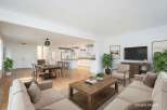 Experience seamless open-concept living in this beautifully staged home, featuring a spacious dining area adjacent to a modern white kitchen with ample counter space and bar seating.