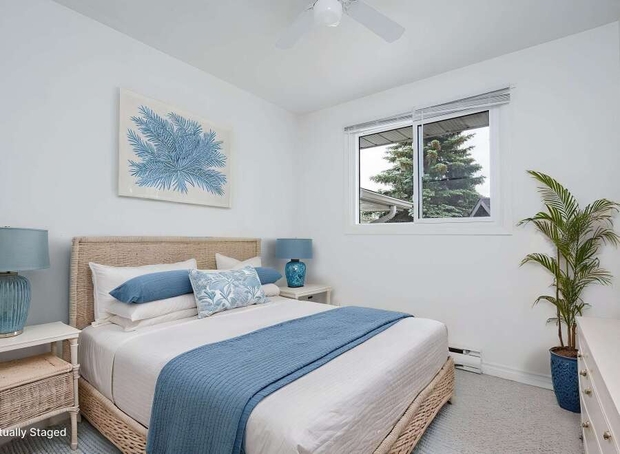 Experience coastal charm in this serene bedroom, featuring a light and airy atmosphere with a woven headboard and calming blue accents.