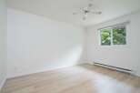 This bright and airy room features a ceiling fan for optimal air circulation and a large window offering abundant natural light.