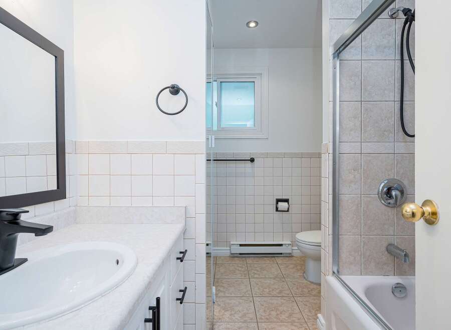 This bathroom features a modern black faucet and a sleek vanity with ample counter space.