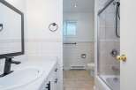 This bathroom features a modern black faucet and a sleek vanity with ample counter space.