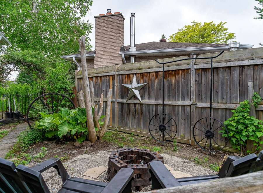 Enjoy cozy evenings in this backyard oasis, complete with a rustic brick fire pit and comfortable seating.