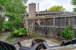 Enjoy cozy evenings in this backyard oasis, complete with a rustic brick fire pit and comfortable seating.