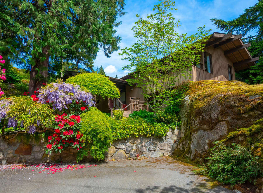 Nestled amidst lush greenery and vibrant blooms, this charming home offers a serene retreat.