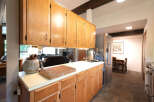 This spacious kitchen features warm wooden cabinetry, a large butcher block, and a sleek stainless steel refrigerator.