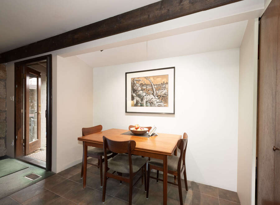 This dining area features a charming wooden table with four chairs, perfect for intimate meals.