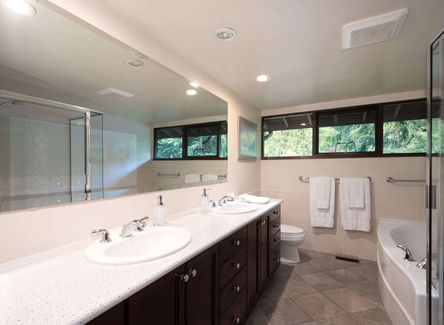 This spacious bathroom features a double vanity with ample counter space and storage, perfect for any couple.