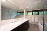 This spacious bathroom features a double vanity with ample counter space and storage, perfect for any couple.