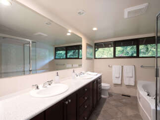 This spacious bathroom features a double vanity with ample counter space and storage, perfect for any couple.
