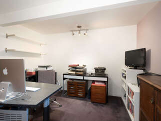 This home office features a large desk with an Apple iMac computer, perfect for productivity.