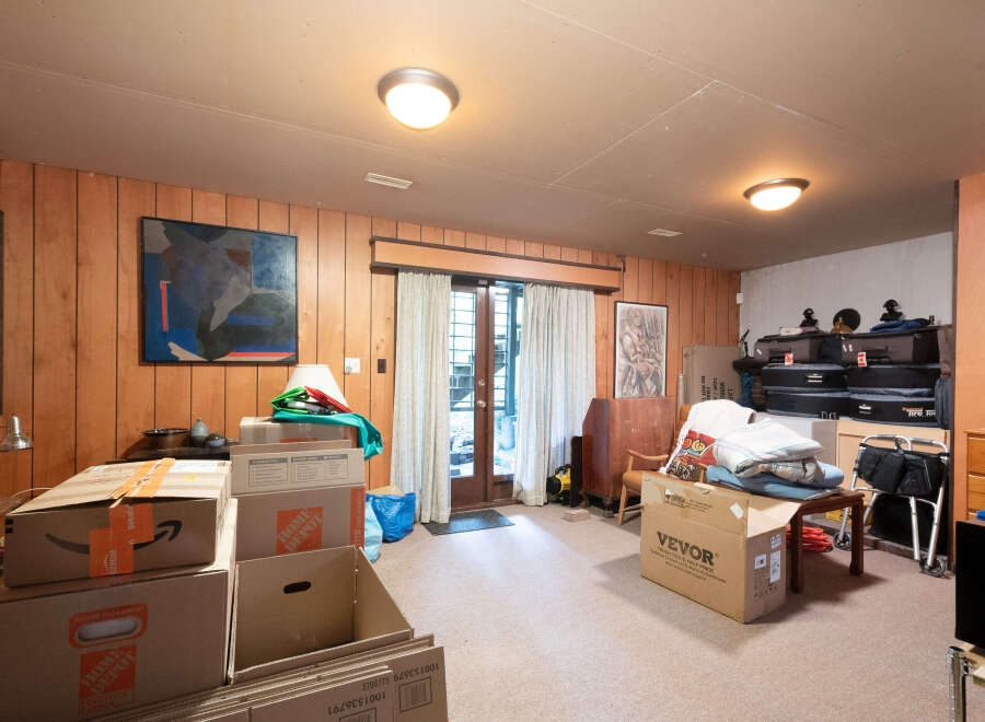 This spacious room features wood-paneled walls and a neutral carpet, creating a warm and inviting atmosphere.