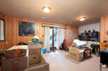 This spacious room features wood-paneled walls and a neutral carpet, creating a warm and inviting atmosphere.