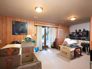 This spacious room features wood-paneled walls and a neutral carpet, creating a warm and inviting atmosphere.