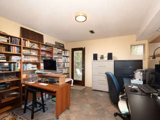 This home office features extensive built-in bookshelves filled with a diverse collection of books, creating a studious and organized atmosphere.
