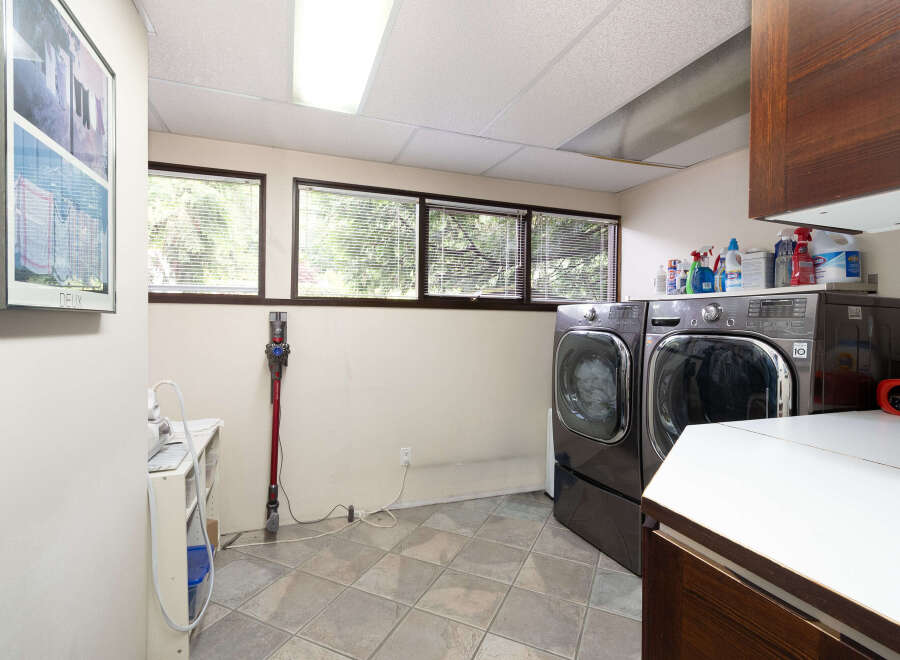 This laundry room features a spacious layout with a large capacity washer and dryer set, perfect for handling family-sized loads.