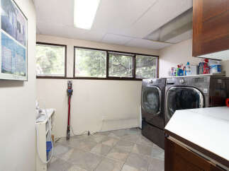 This laundry room features a spacious layout with a large capacity washer and dryer set, perfect for handling family-sized loads.