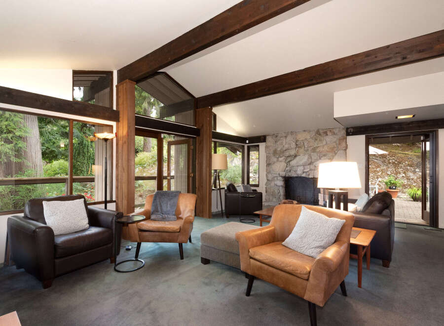 Experience the warmth of this inviting living room, featuring a stunning stone fireplace and exposed wooden beams that add rustic charm.