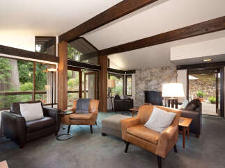 Experience the warmth of this inviting living room, featuring a stunning stone fireplace and exposed wooden beams that add rustic charm.