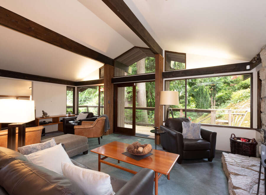 Experience the ultimate in rustic charm with this stunning living room, featuring soaring vaulted ceilings with exposed wooden beams and a magnificent stone fireplace.