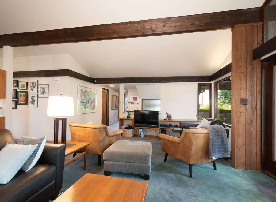 Experience the warmth of this inviting living room, featuring rich wood beams and a cozy seating arrangement.