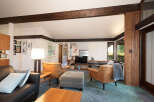 Experience the warmth of this inviting living room, featuring rich wood beams and a cozy seating arrangement.