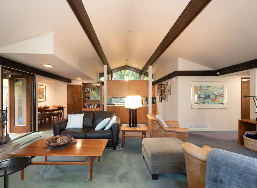 Experience the warmth and character of this inviting living space, featuring a rich leather sofa and comfortable armchairs perfect for relaxation.