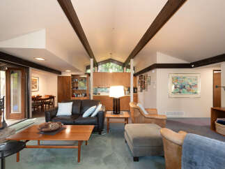 Experience the warmth and character of this inviting living space, featuring a rich leather sofa and comfortable armchairs perfect for relaxation.