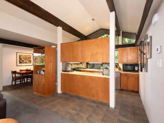 Discover this stunning home featuring a modern kitchen with rich wood cabinetry and sleek countertops, perfect for culinary enthusiasts.