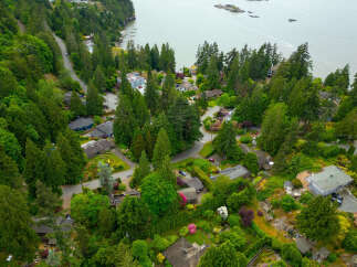Discover this stunning aerial view of a lush, green neighborhood nestled beside a serene body of water.