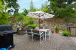 Enjoy outdoor living with this spacious patio featuring a dining set and umbrella, perfect for al fresco meals.