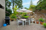 Enjoy outdoor living with this charming patio featuring a dining set and umbrella, perfect for al fresco meals.