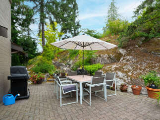 Enjoy outdoor living with this charming patio featuring a dining set and umbrella, perfect for al fresco meals.