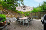 Enjoy outdoor living with this spacious patio featuring a dining set and umbrella, perfect for al fresco meals.