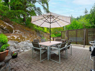 Enjoy outdoor living with this spacious patio featuring a dining set and umbrella, perfect for al fresco meals.