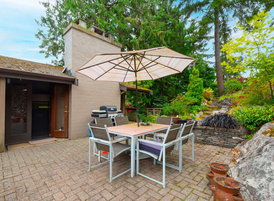 Enjoy outdoor living with this charming patio featuring a dining set and umbrella, perfect for al fresco meals.