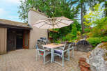 Enjoy outdoor living with this charming patio featuring a dining set and umbrella, perfect for al fresco meals.
