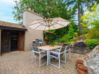 Enjoy outdoor living with this charming patio featuring a dining set and umbrella, perfect for al fresco meals.