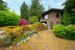 Nestled amidst lush greenery and vibrant rhododendrons, this charming home offers a serene retreat.