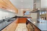 Experience luxury mountain living in this stunning kitchen featuring sleek, wood-grain cabinetry and expansive dark countertops.