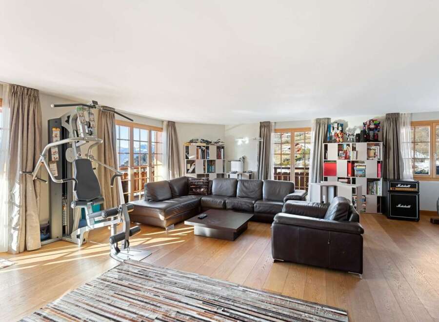Experience ultimate relaxation and fitness in this spacious living area, featuring a comprehensive home gym setup.