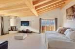 Experience luxury mountain living in this stunning bedroom featuring a modern fireplace and a wall-mounted TV.