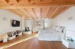 Experience cozy living in this charming bedroom featuring a modern fireplace and a large, comfortable bed.