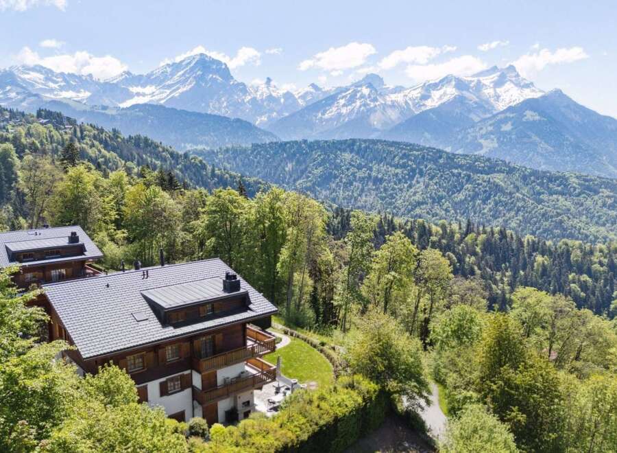 Experience breathtaking mountain vistas from this stunning chalet, nestled amidst lush greenery.