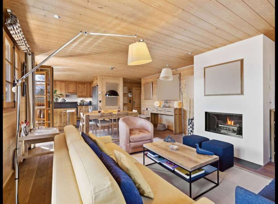 Experience luxurious mountain living in this stunning open-concept living space, featuring a cozy fireplace and a fully equipped kitchen perfect for entertaining.