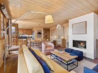 Experience luxurious mountain living in this stunning open-concept living space, featuring a cozy fireplace and a fully equipped kitchen perfect for entertaining.