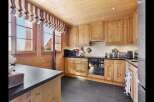 Experience rustic charm in this beautifully appointed wooden kitchen, featuring warm pine cabinetry and a sleek black countertop.