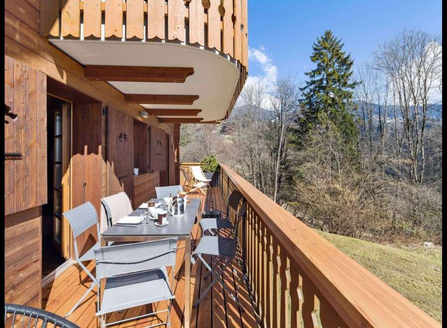 Enjoy breathtaking mountain views from this charming wooden balcony, perfect for al fresco dining or morning coffee.