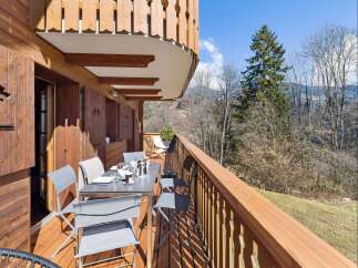 Enjoy breathtaking mountain views from this charming wooden balcony, perfect for al fresco dining or morning coffee.