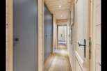 Step into this charming hallway featuring warm, natural wood paneling on the walls and ceiling, creating a cozy and inviting atmosphere.